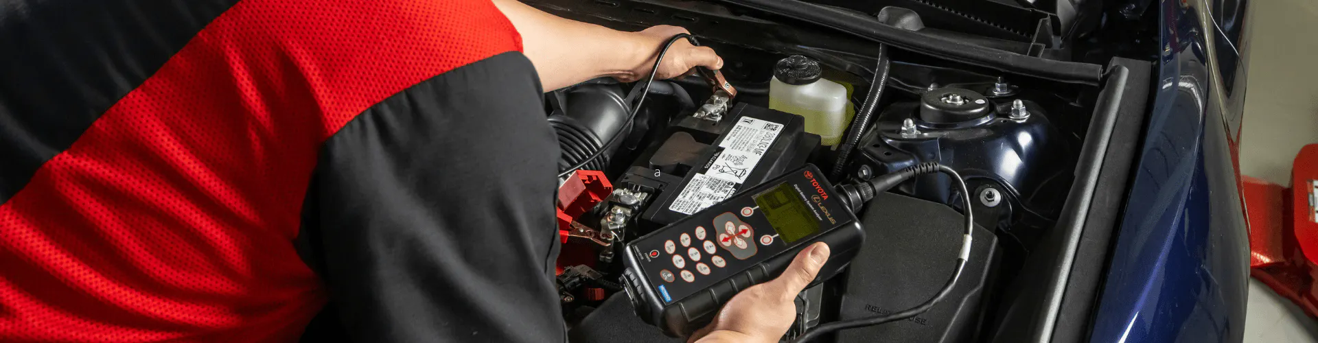 Toyota service technician testing battery inside vehicle