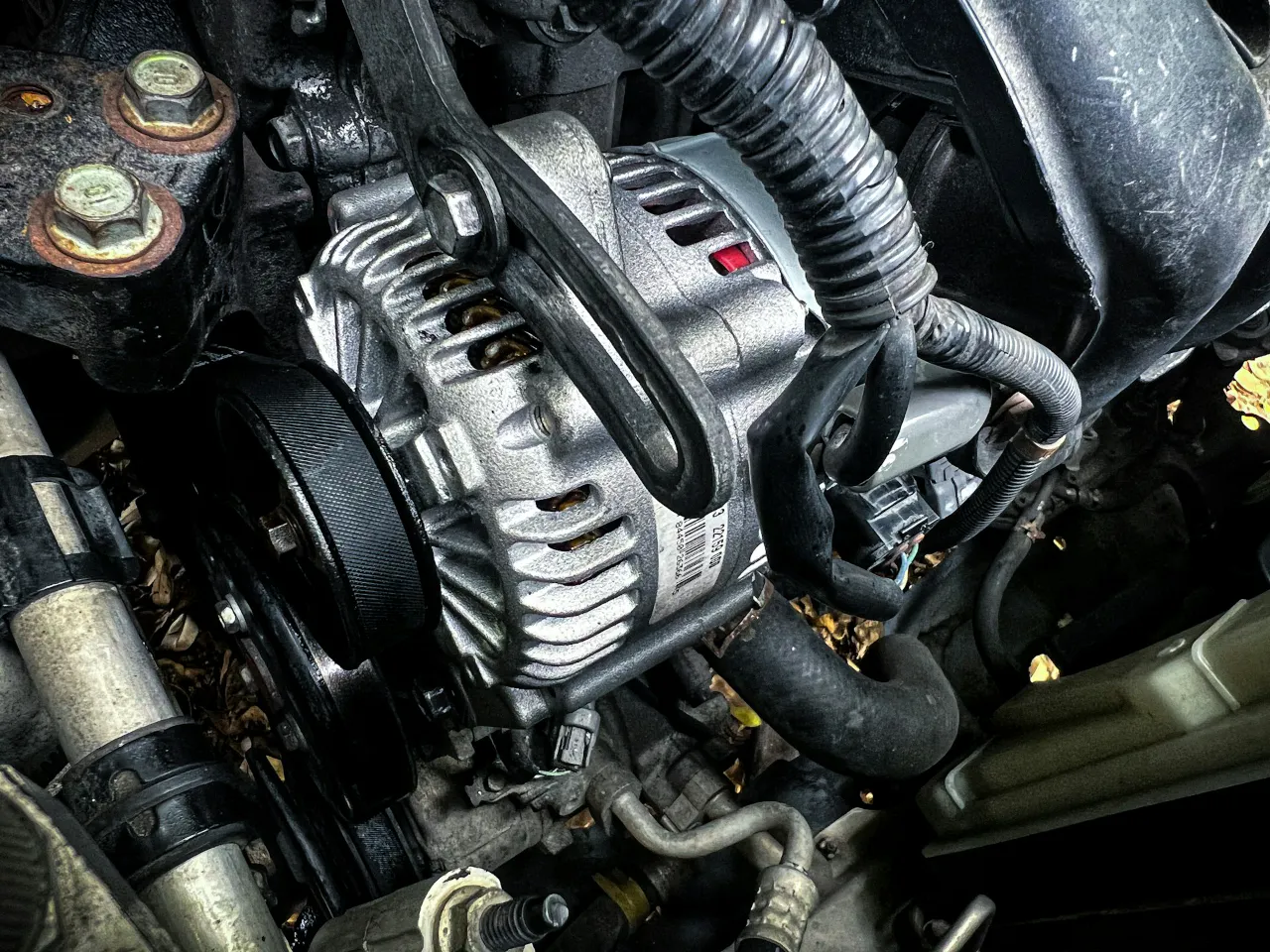 A close up image of an alternator inside an engine bay