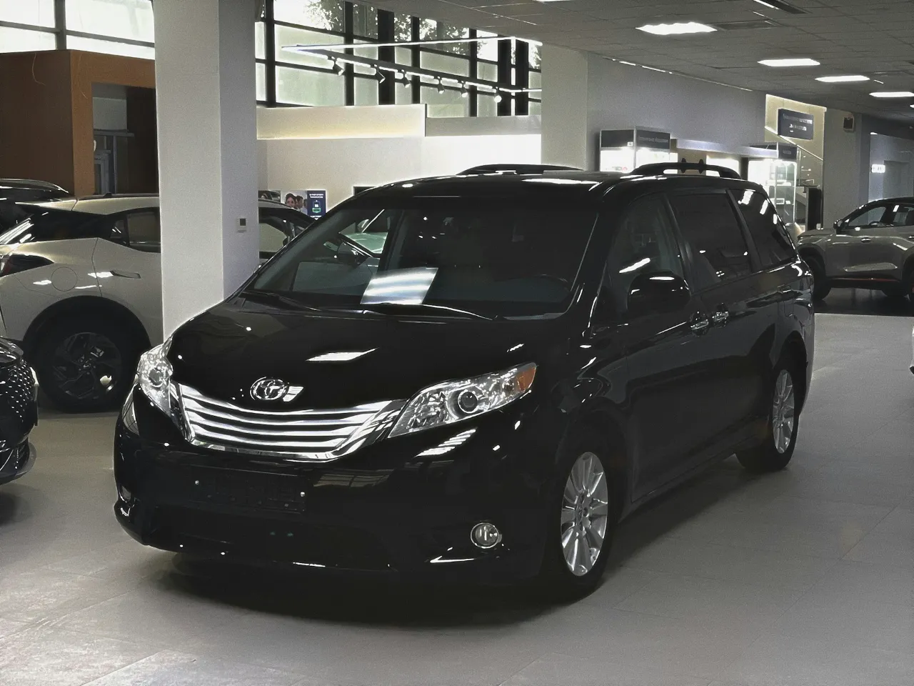 Shiny black Toyota Minivan in a showroom
