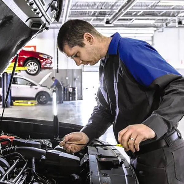 Technician looking at underside of car