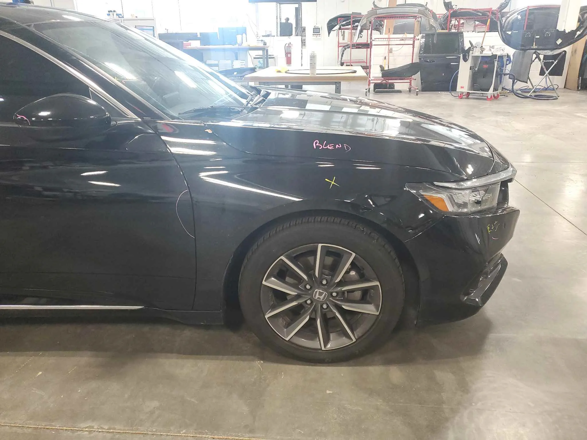 Black Honda SUV with front fender damage before repair