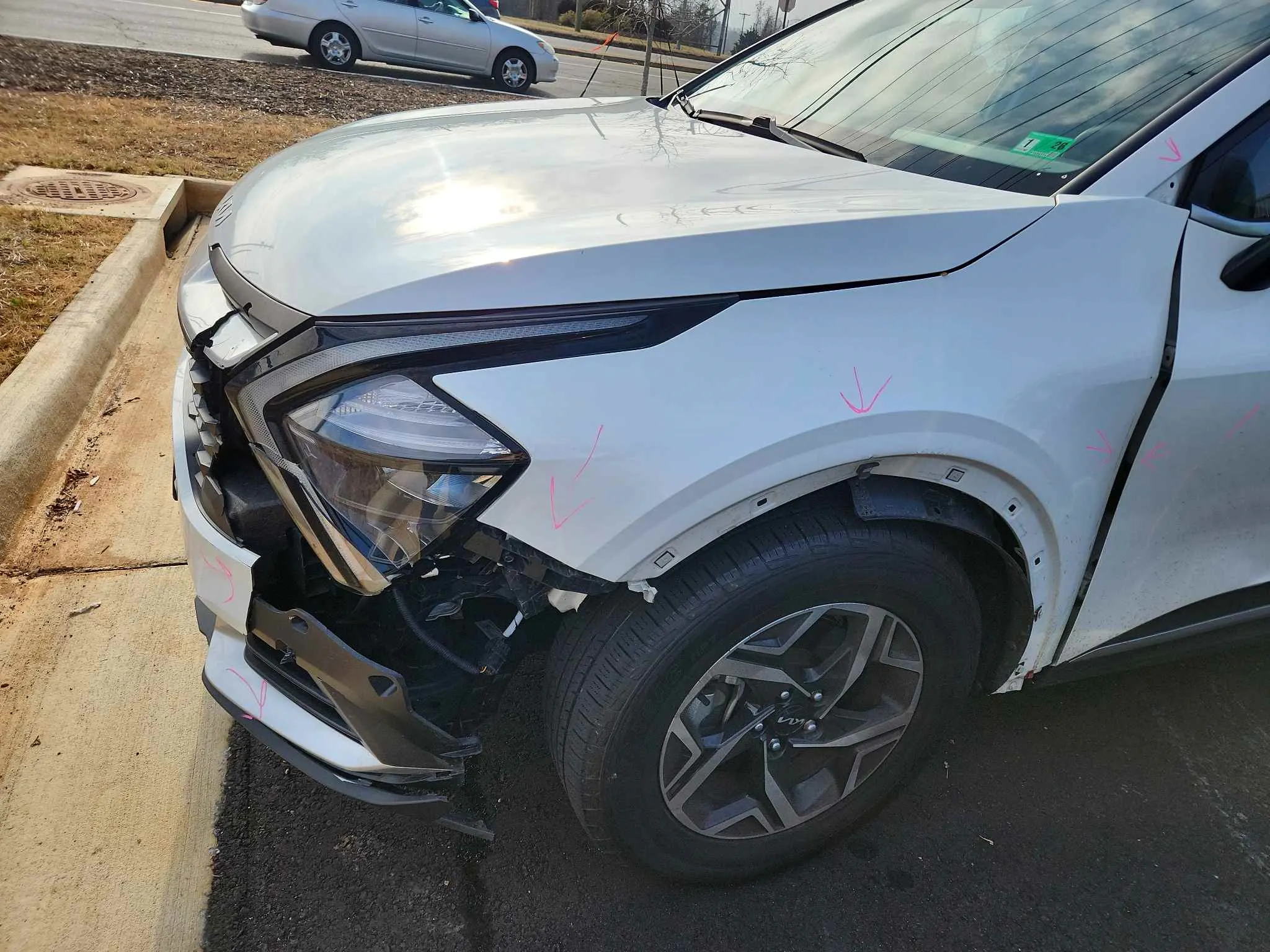 Kia SUV with front fender damage before repair