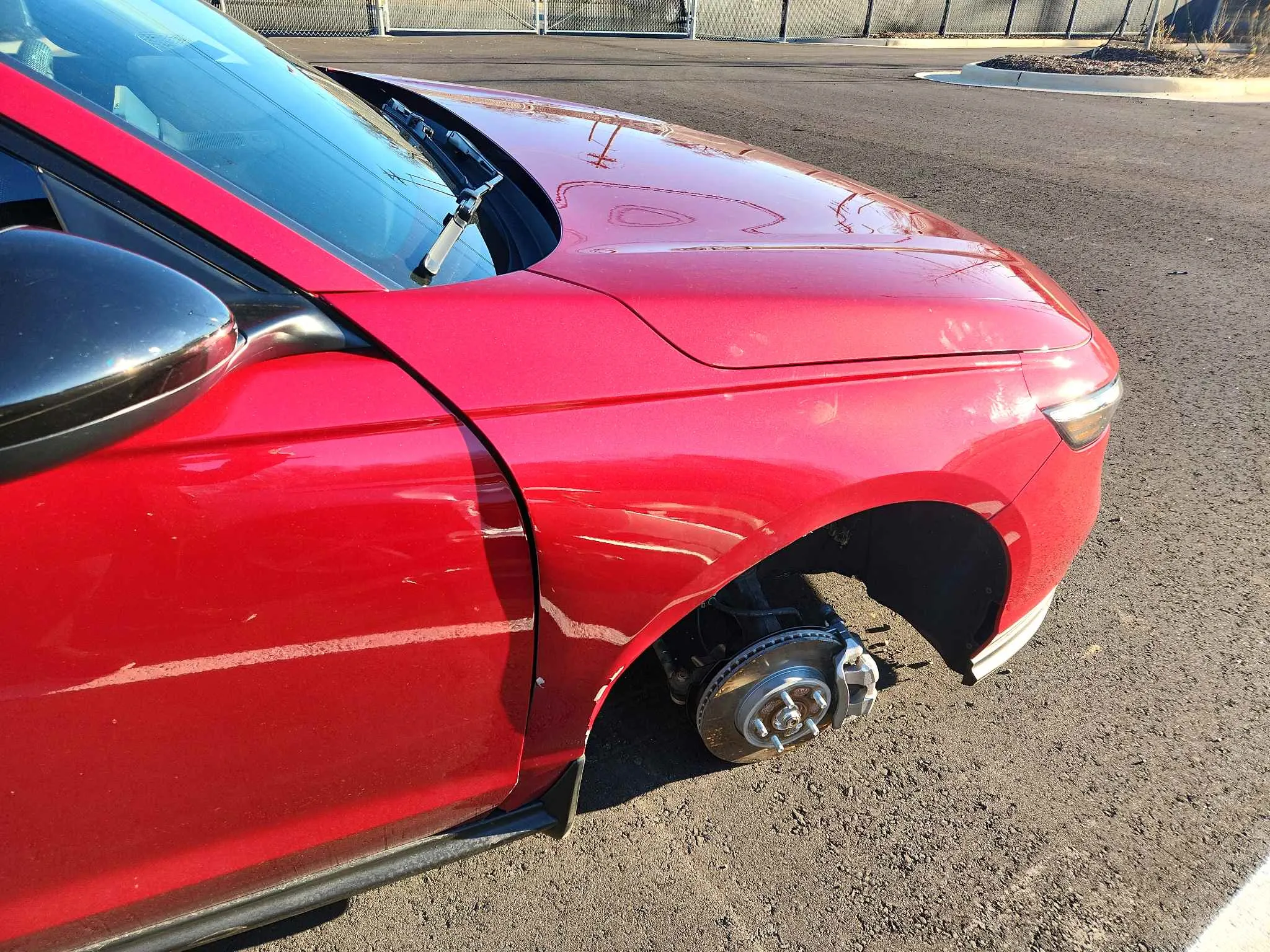 Red vehicle with front fender damage before repair