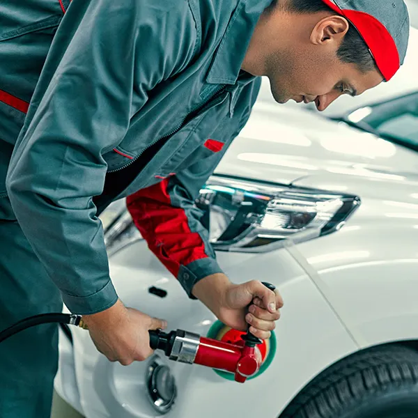 Technician performing paintless dent repair on a vehicle