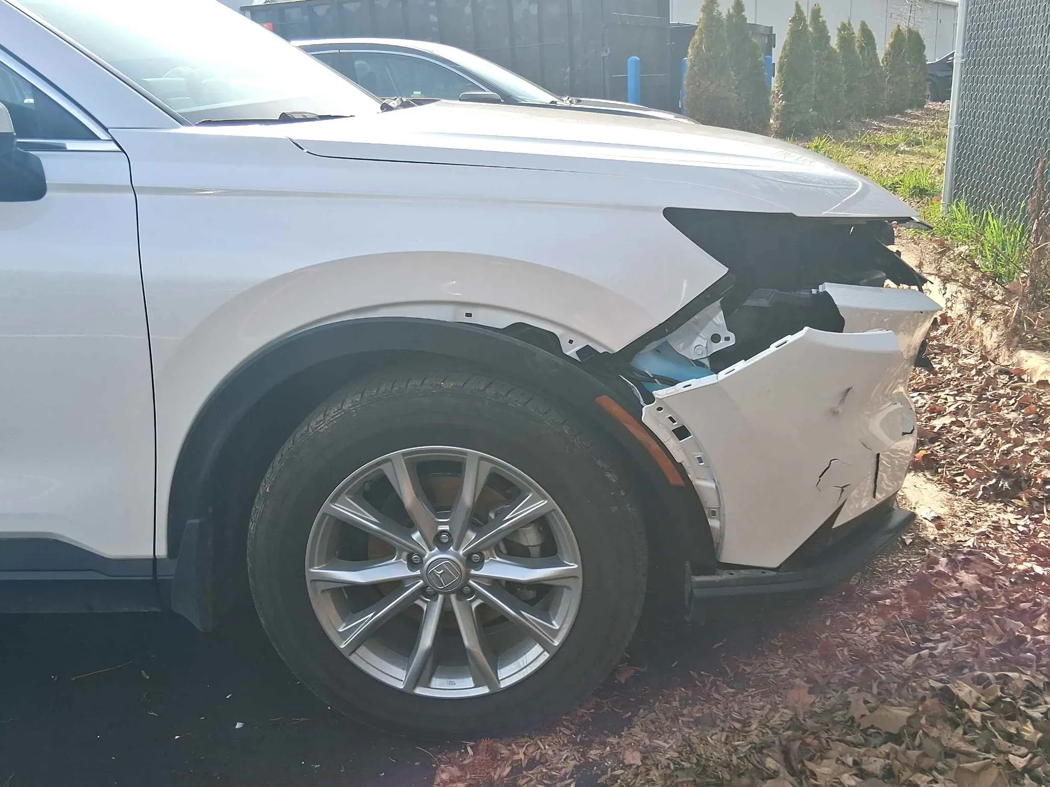 White vehicle with front bumper damage before repair