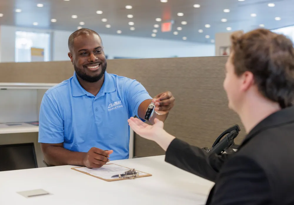 Customer receiving vehicle keys at an Acura dealership