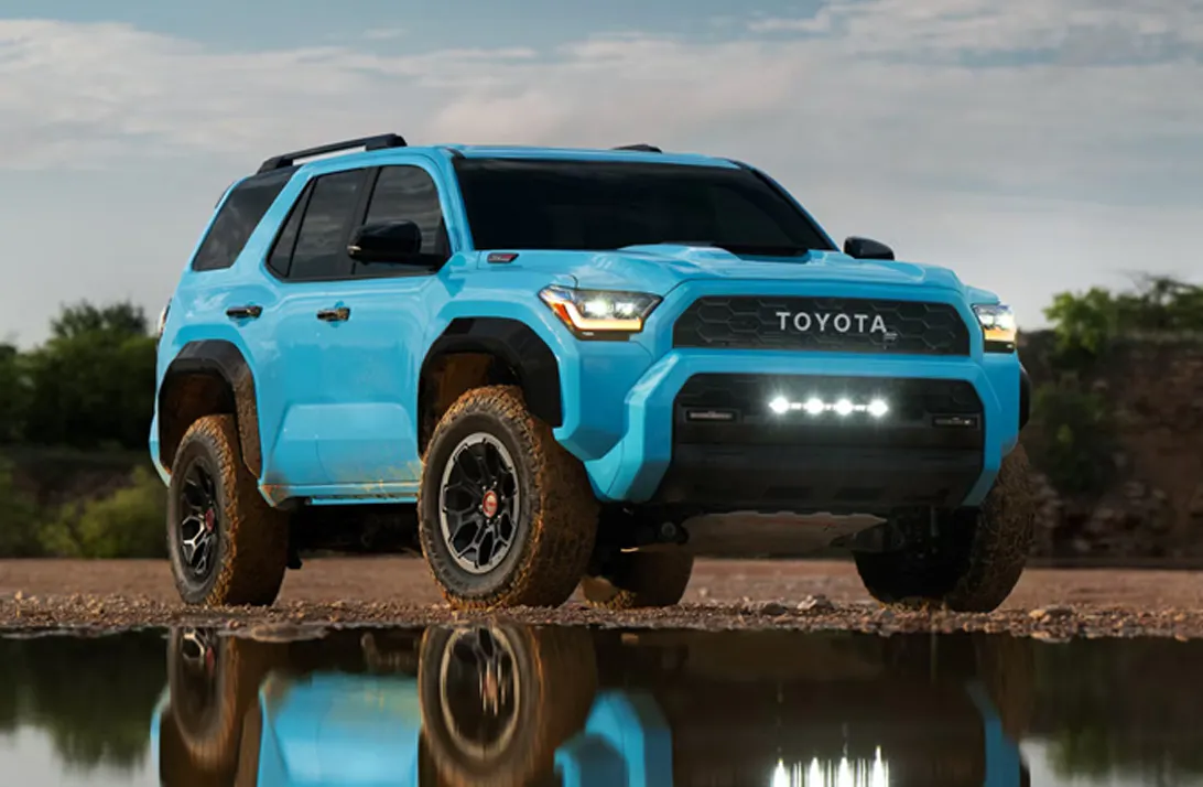 Blue Toyota 4Runner parked beside a reflective pool of water