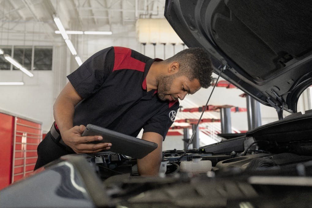 Toyota Technician inspecting car battery