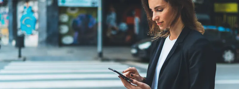 Woman using a mobile device with connected vehicle features
