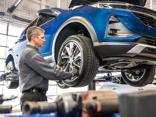 Blue vechiles on service lift getting tires serviced