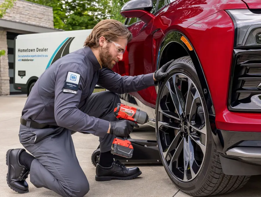 Service technician working on a red vehicle with an impact gun