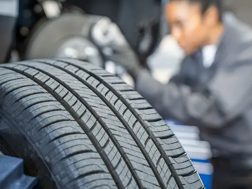 Close up of tire tread with tech in background