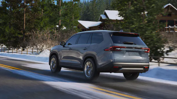 Gray Toyota Grand Highlander heading toward a snow-covered cabin