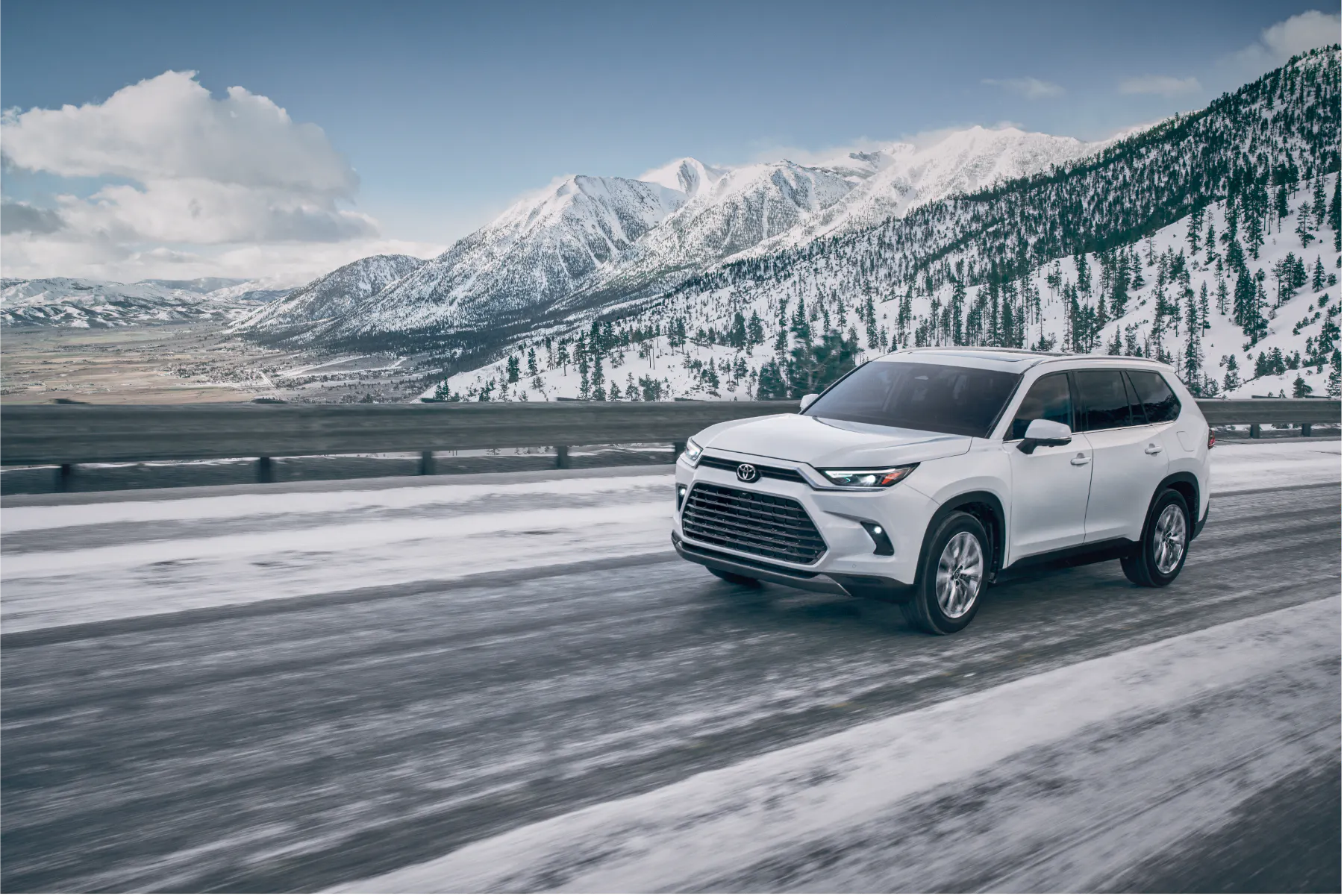 Toyota Grand Highlander driving on a snowy mountain road