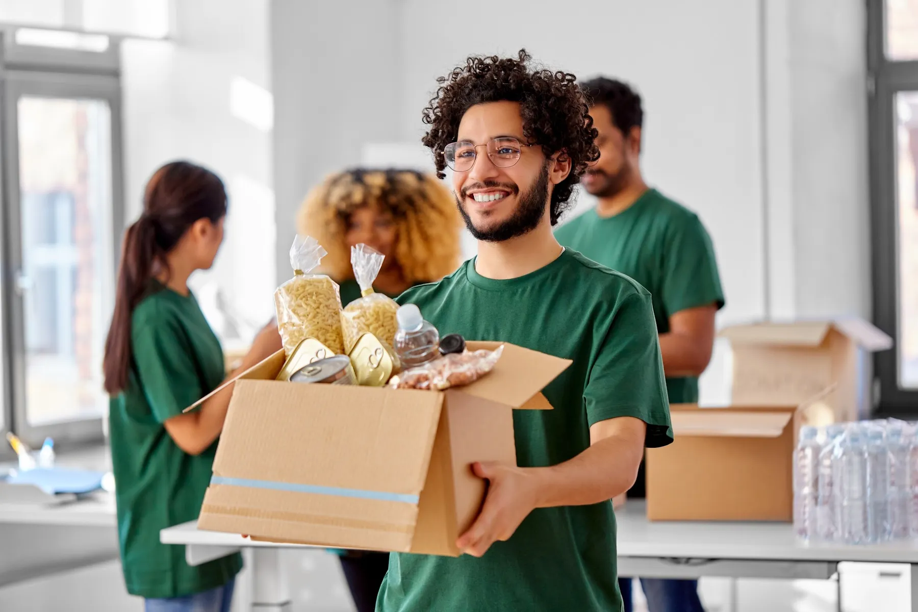 Volunteers carrying a box of donated food