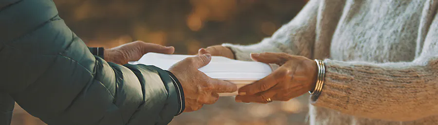 A warm meal being handed to a person in need