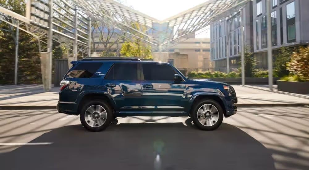 A blue 2023 Toyota 4Runner TRD Sport is shown driving in a city.