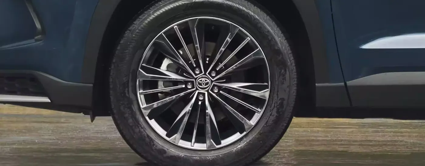 Chrome wheel of a blue 2024 Toyota Grand Highlander