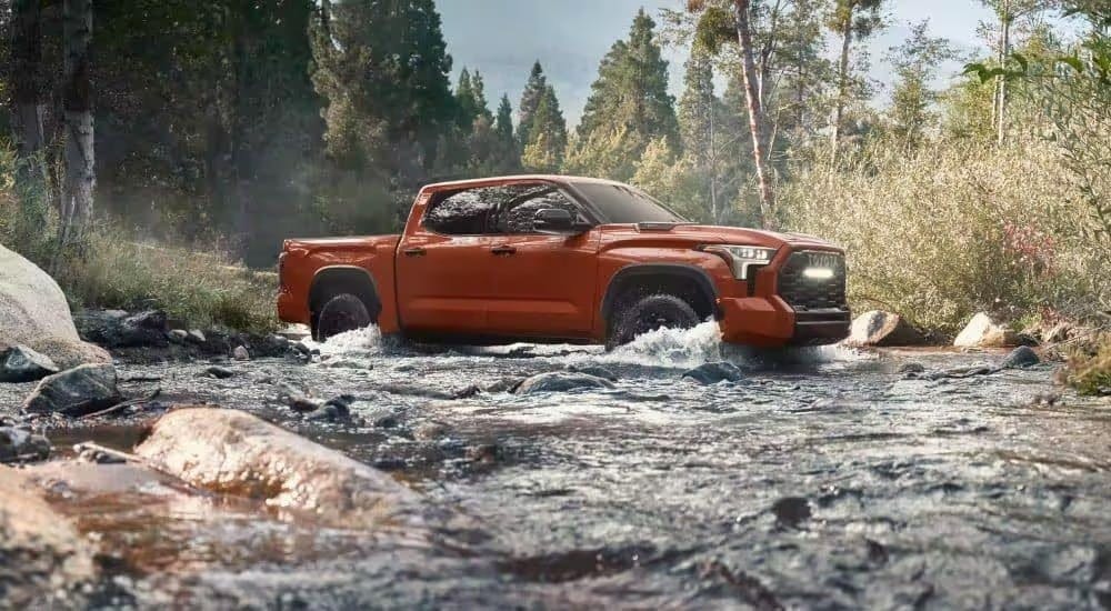 Orange 2024 Toyota Tundra TRD Pro fording a river.