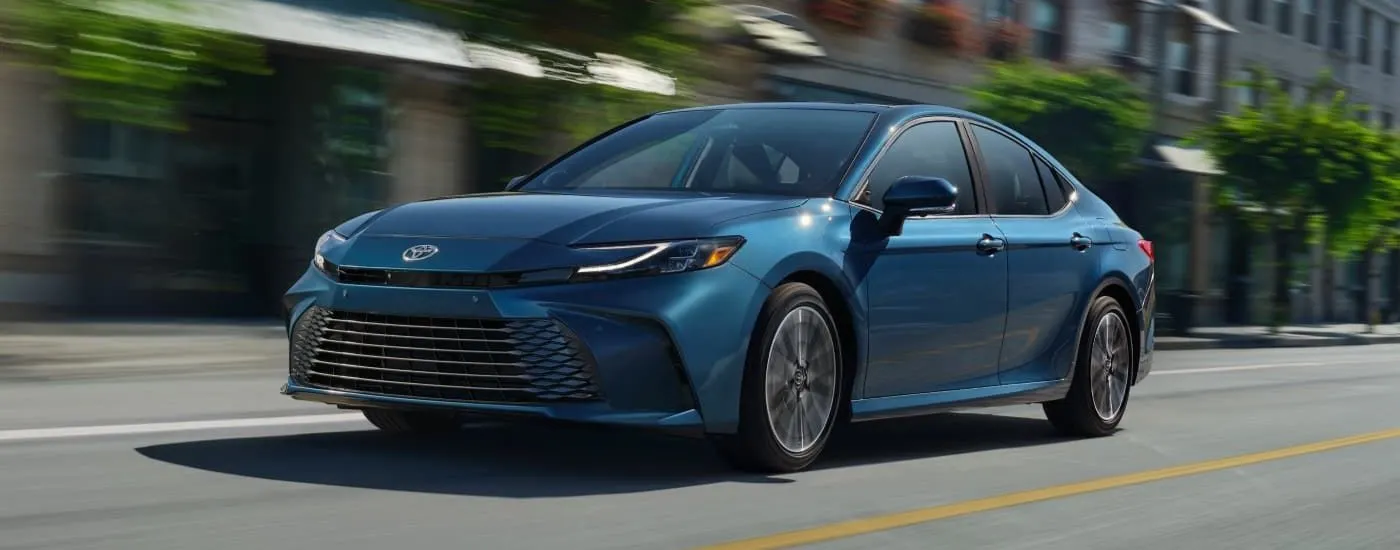 Blue 2026 Toyota Camry driving through a city