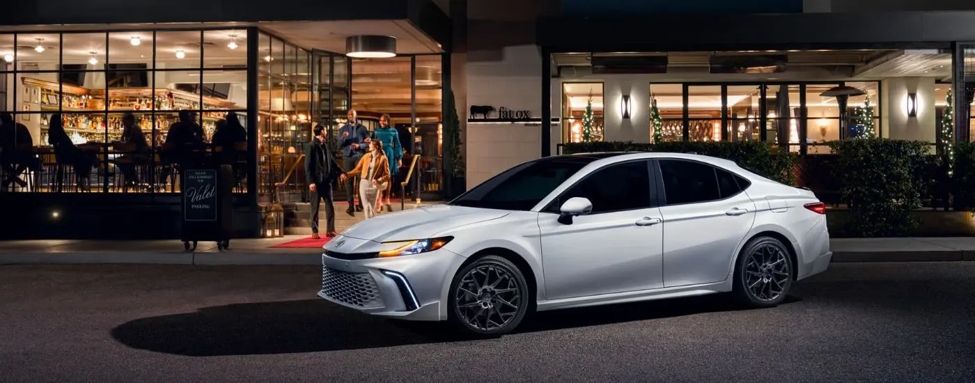 White 2026 Toyota Camry XSE parked outside of a restaurant at night