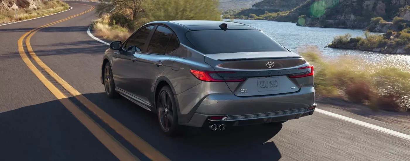 Grey 2026 Toyota Camry XSE driving past a lake