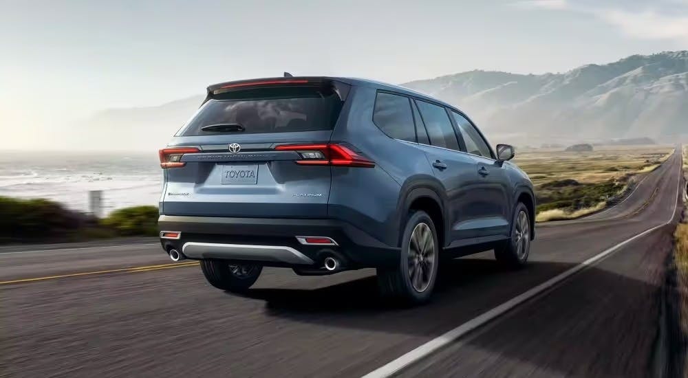 A blue 2025 Toyota Grand Highlander is shown from the rear at an angle.