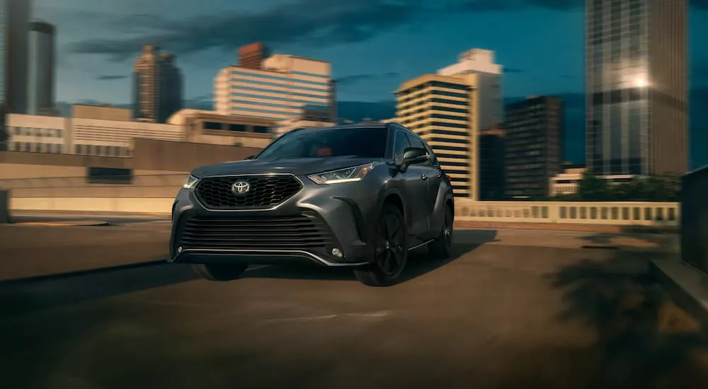 Black 2026 Toyota Highlander driving across a bridge.