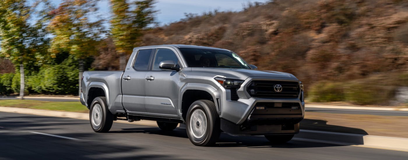 Silver 2025 Toyota Tacoma driving down the street