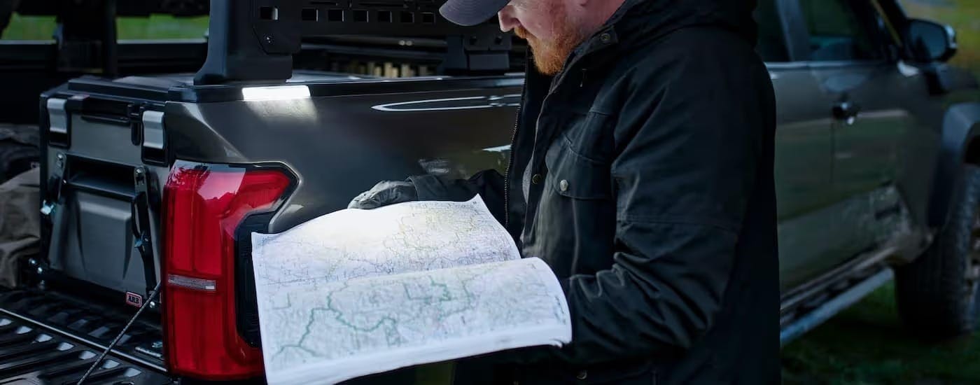 A man using an accessory light for a 2025 Toyota Tacoma