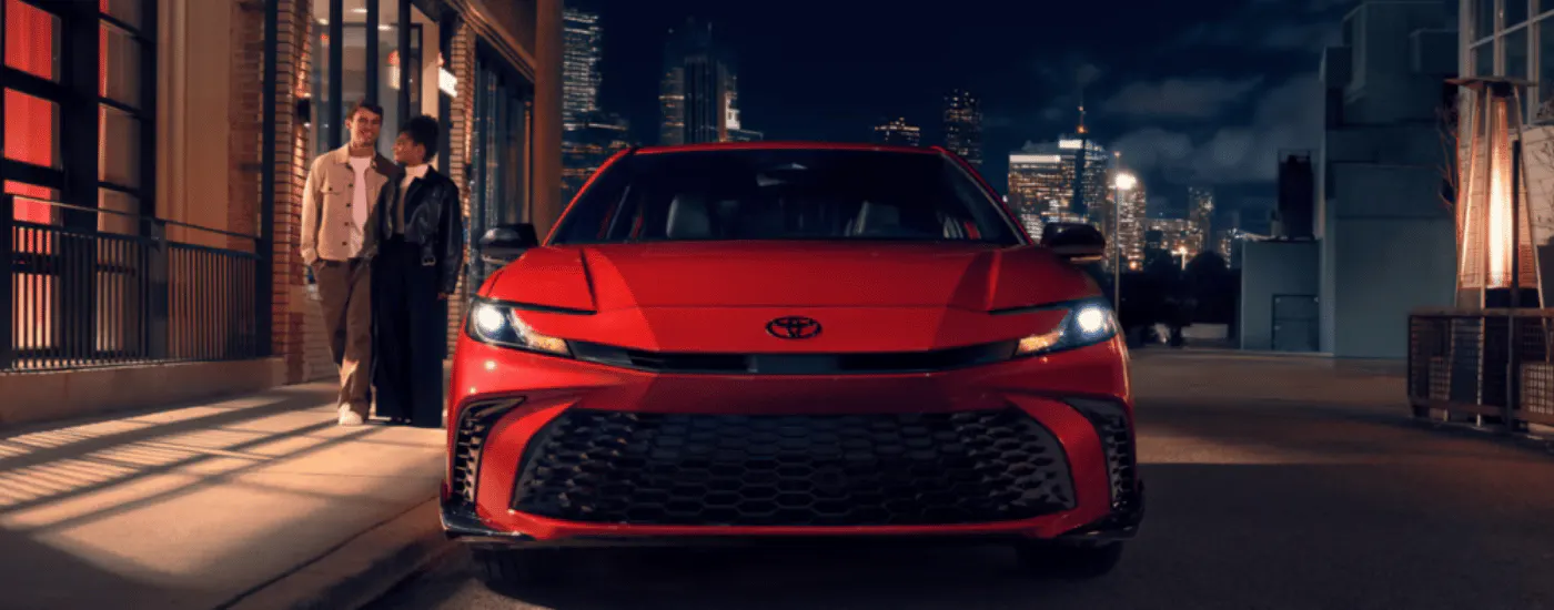 Red 2026 Toyota Camry parked head-on at night
