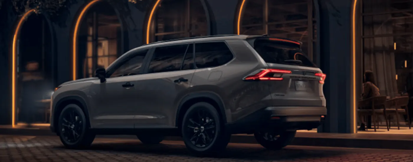 Grey 2026 Toyota Grand Highlander driving past arches at night