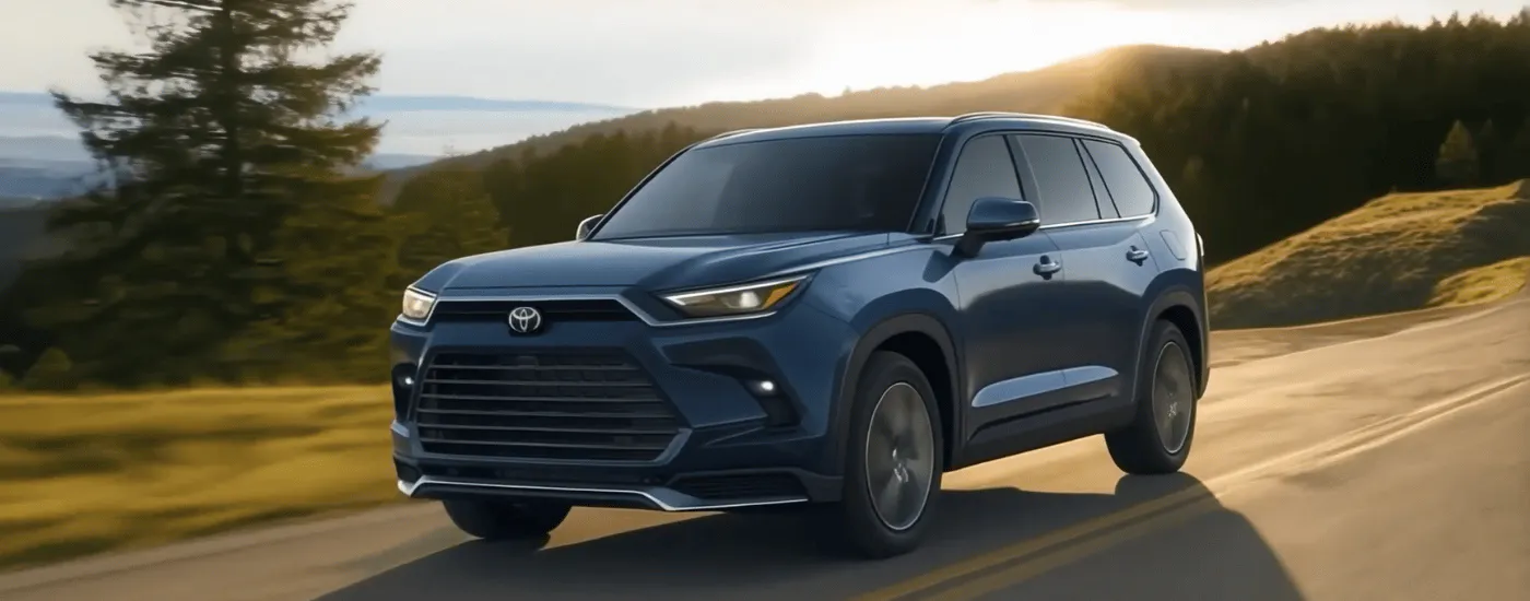 Blue 2026 Toyota Grand Highlander driving along a ridgeline