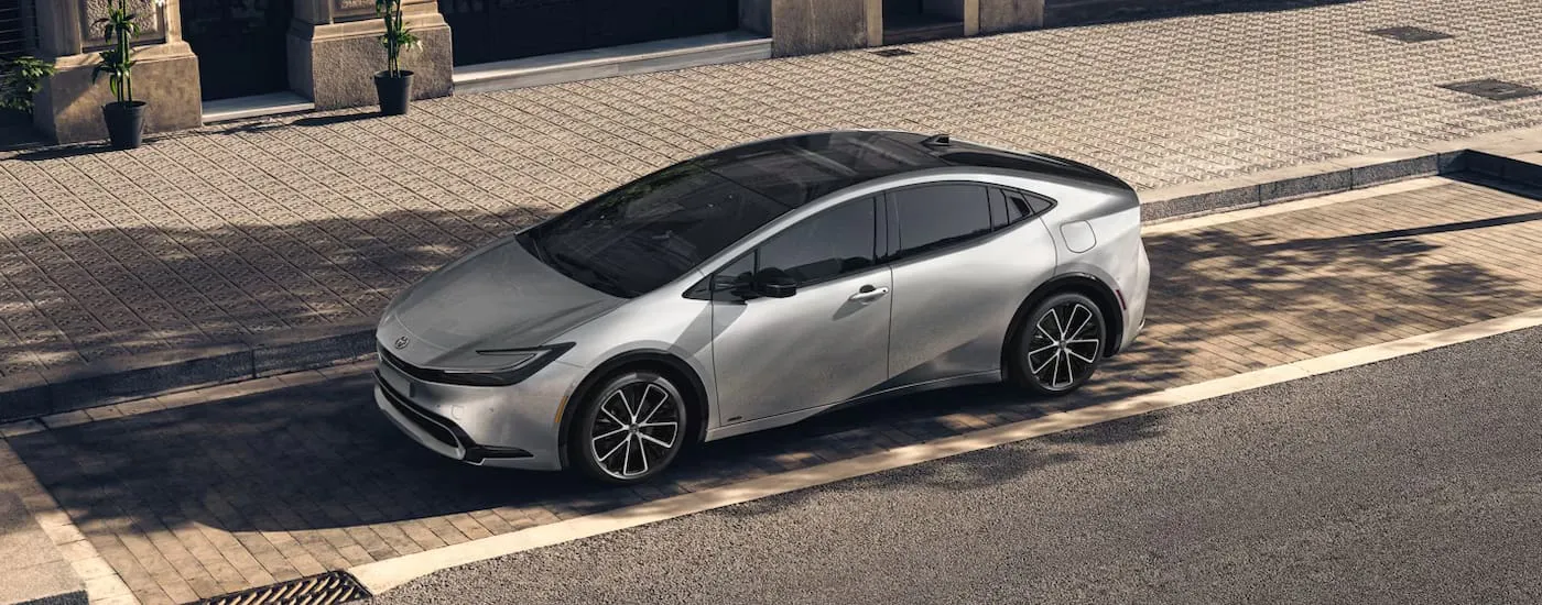 Silver 2026 Toyota Prius parked by a curb.