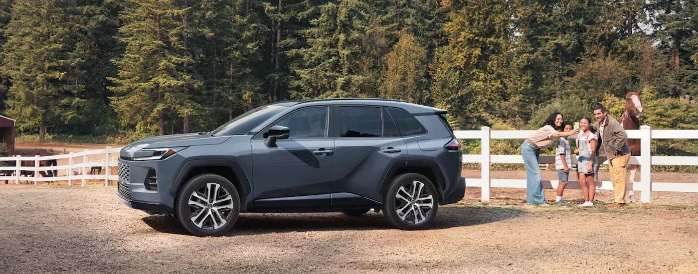 Grey 2026 Toyota RAV4 parked on a farm near a white fence