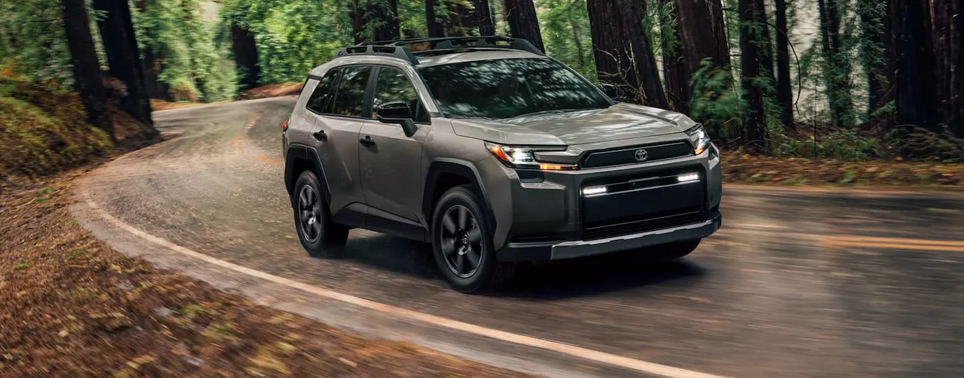 Grey 2026 Toyota RAV4 driving around a bend.