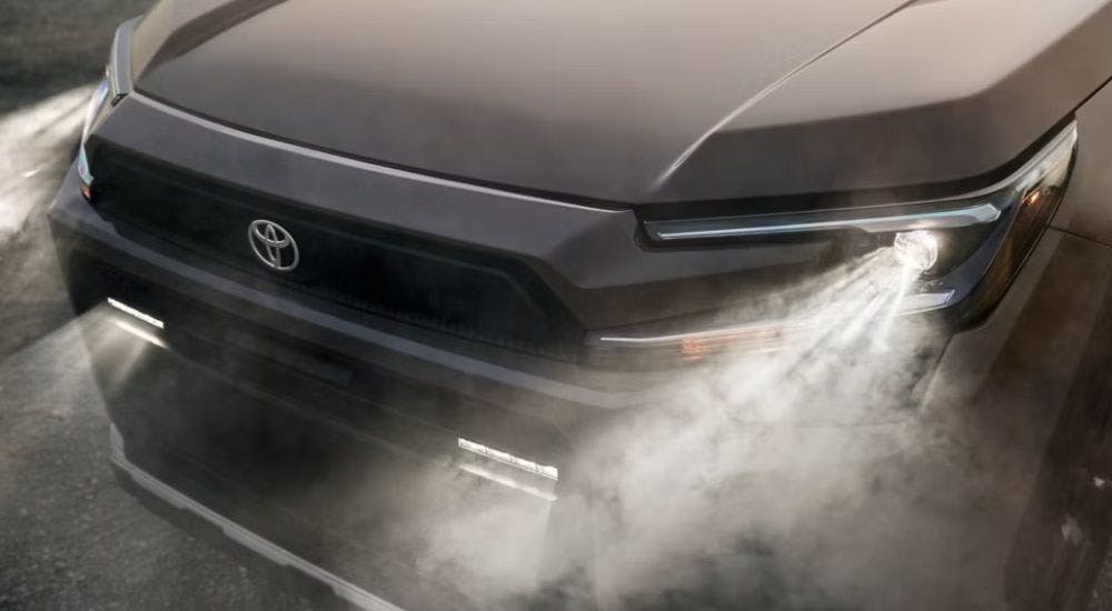 Illuminated headlights on a grey 2026 Toyota RAV4