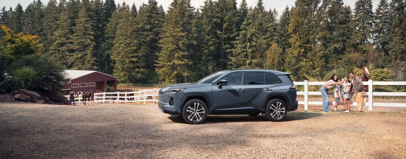 Family taking a photo near a grey 2026 Toyota RAV4 Limited