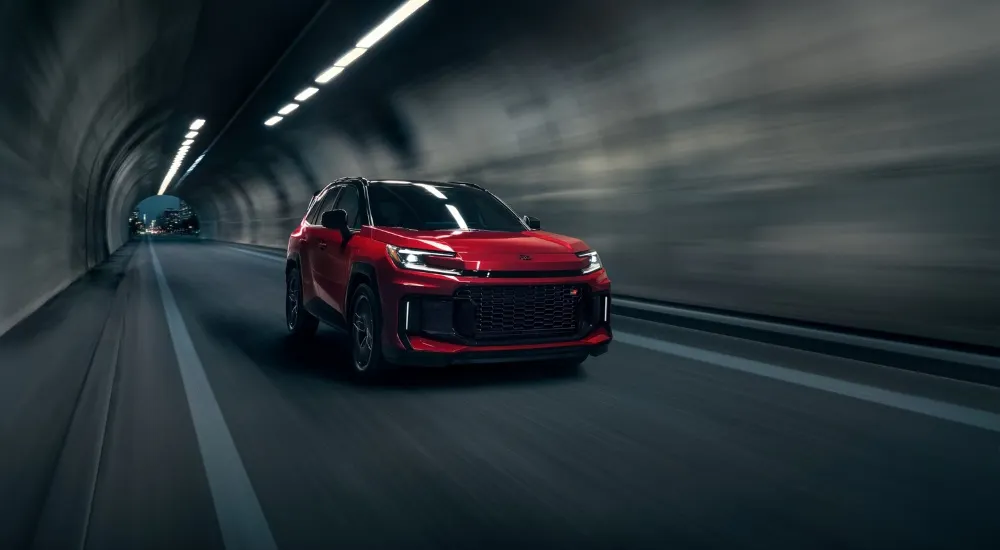 Red 2026 Toyota RAV4 PHEV GR Sport driving through a tuennl
