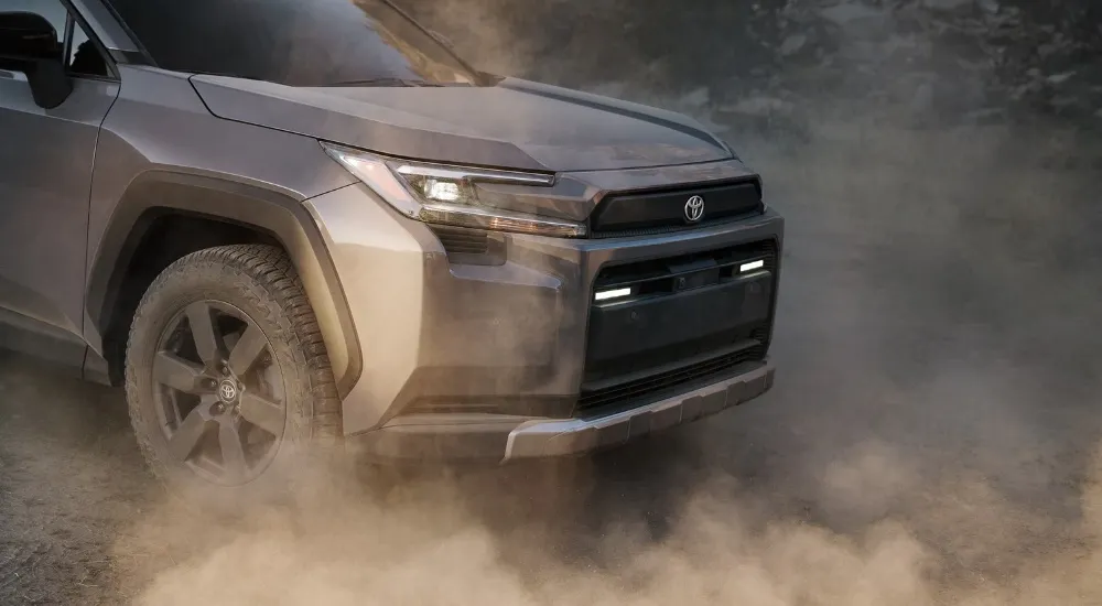 Grey 2026 Toyota RAV4 Woodland kicking up dust