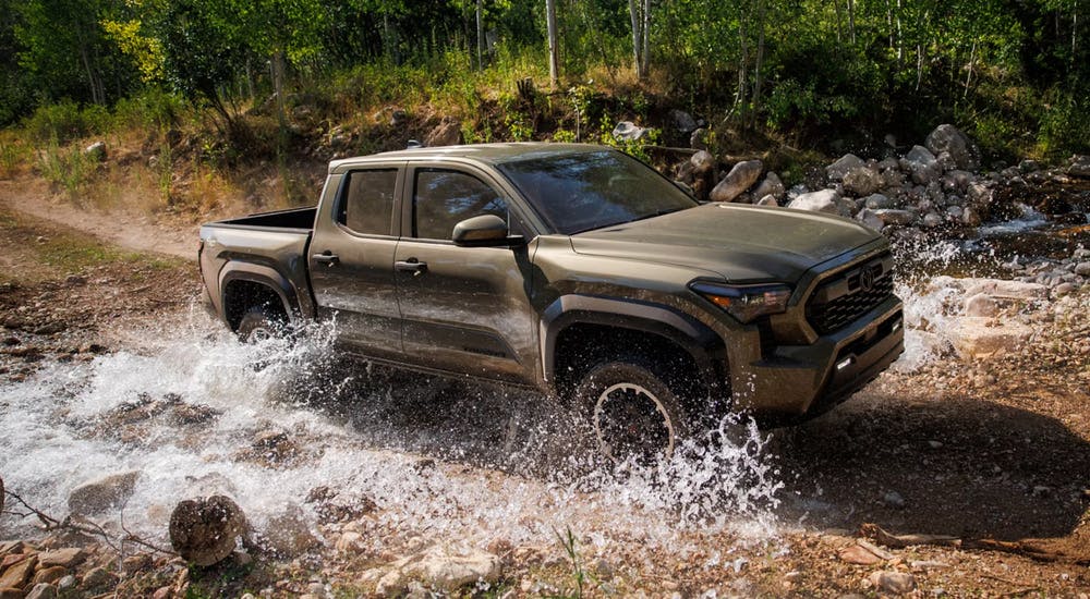 Brown 2026 Toyota Tacoma off-roading through a stream