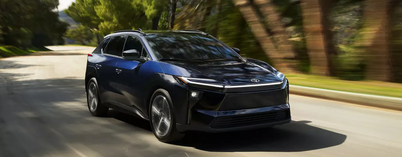 Black 2026 Toyota bZ driving down an open road.