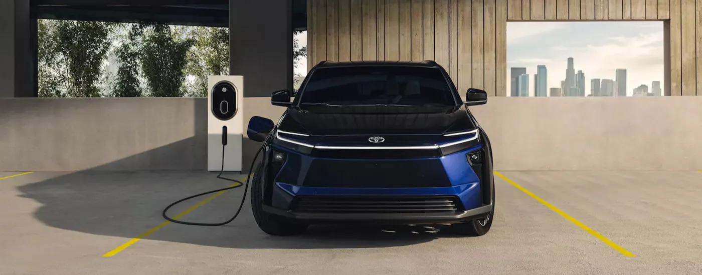 Front of a dark blue 2026 Toyota bZ parked in a garage and charging.