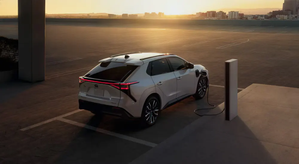 White 2026 Toyota bZ charging at sunset