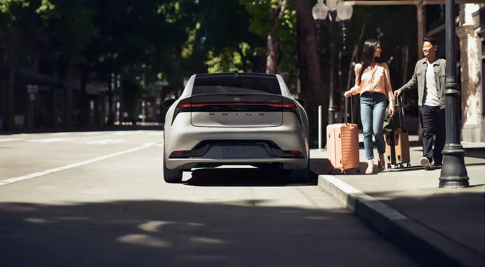 Rear of a white 2026 Toyota Prius parked by a curb.