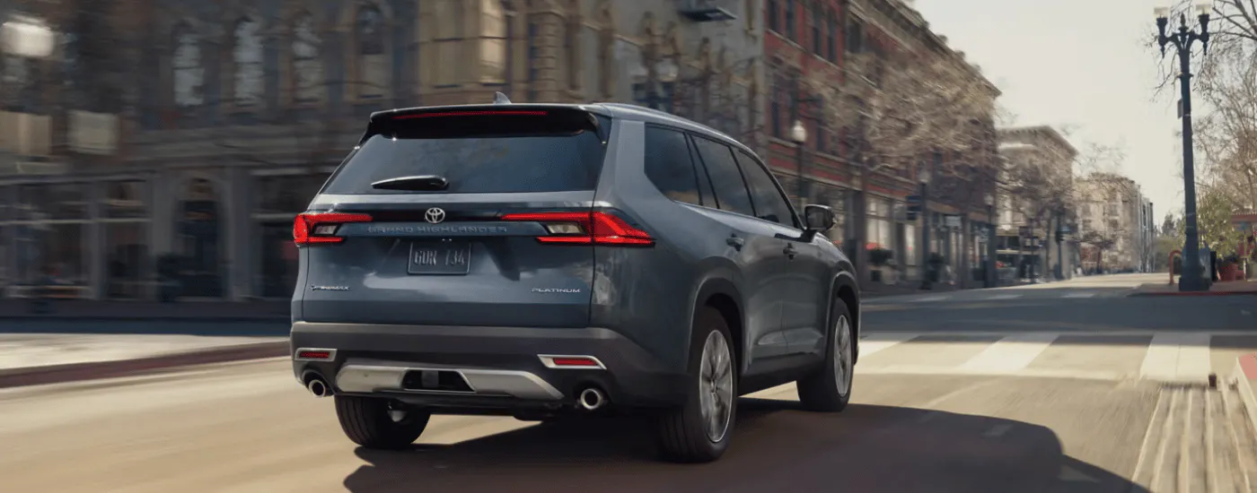 Blue 2026 Toyota Grand Highlander driving through a city
