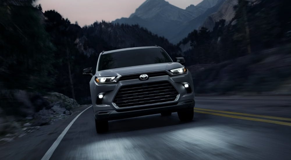 Grey 2025 Toyota Grand Highlander Hybrid Nightshade driving on a highway