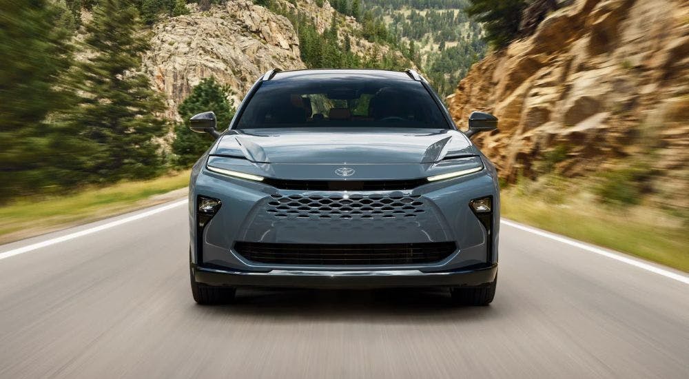 A light blue 2025 Toyota Crown Signia is shown driving from a Roswell Toyota dealer.