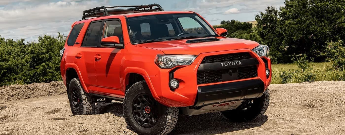 Orange 2025 Toyota 4Runner TRD parked off-road.