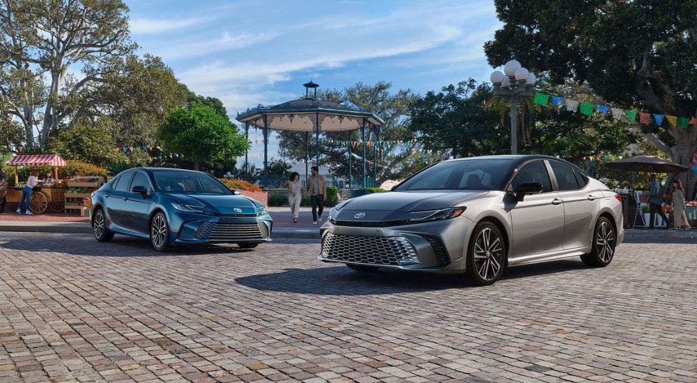 A grey and a blue 2025 Toyota Camry parked beside each other